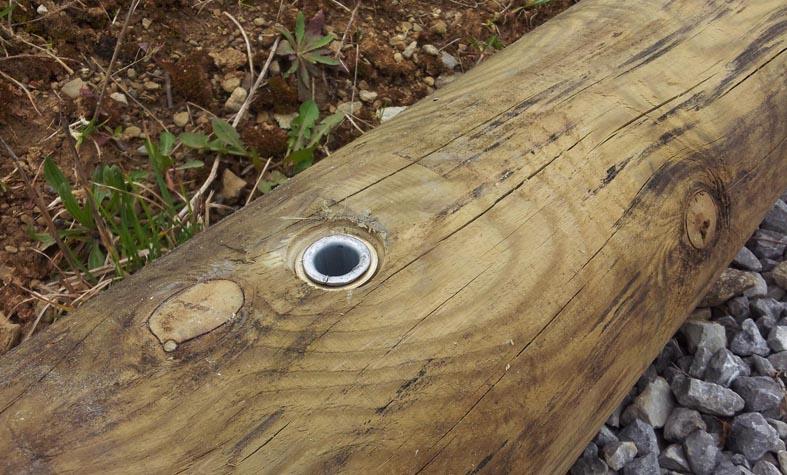 Comment fixer des rondins de bois dans le sol ?